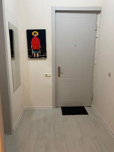 a hallway with a white door and a picture on the wall at Cultural Crossing Hotel in Tbilisi City