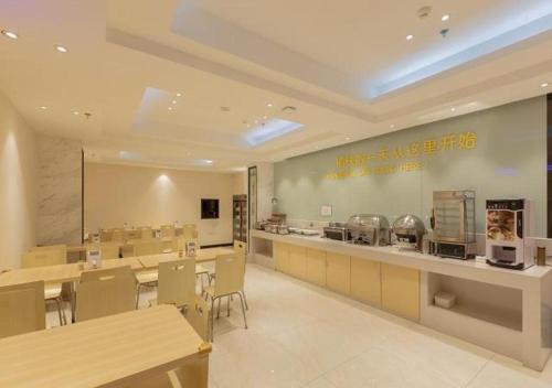 a restaurant with a cafeteria with tables and chairs at City Comfort Inn Liuzhou Wuxing Walking Street in Liuzhou