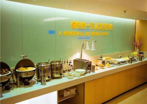 a kitchen with a counter with food on it at City Comfort Inn Wuzhou Bus Station in Wuzhou