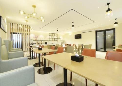 a restaurant with tables and chairs and a dining room at City Comfort Inn Zunyi Meeting Site Medical College in Zunyi