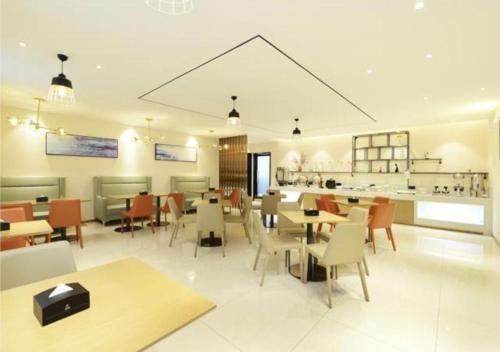 a restaurant with tables and chairs and a bar at City Comfort Inn Zunyi Meeting Site Medical College in Zunyi