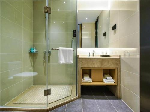 La salle de bains est pourvue d'une douche et d'un lavabo. dans l'établissement City Comfort Inn Chongqing Chayuan Metro Station, à Changshengqiao