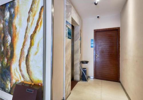 a hallway with a wooden door and a painting on the wall at City Comfort Inn Liuzhou Baisha Bus Station Shengli Barbecue City in Liuzhou