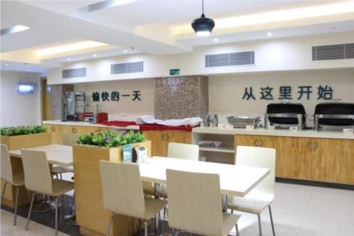 a dining room with white tables and white chairs at City Comfort Inn Wuzhou South High Speed Railway Station in Cangwu