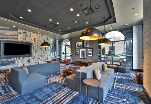 a living room with a couch and a tv at Hilton Garden Inn Savannah Historic District in Savannah