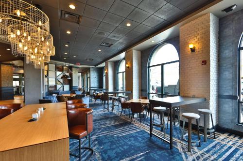 a restaurant with tables and chairs and a chandelier at Hilton Garden Inn Savannah Historic District in Savannah