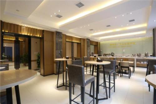 a restaurant with tables and chairs in a room at City Comfort Inn Changsha Jingwanzi Desiqin Plaza in Yangtianhu