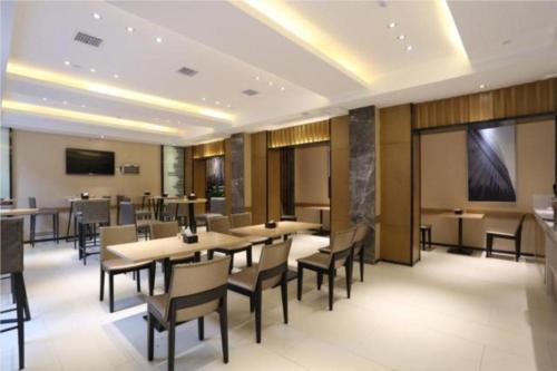 a dining room with tables and chairs and a screen at City Comfort Inn Changsha Jingwanzi Desiqin Plaza in Yangtianhu
