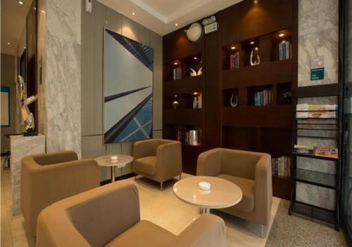 a waiting room with chairs and tables and shelves at City Comfort Inn Hechi Chengxi Avenue in Hechi
