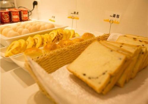 een tafel met een dienblad met brood en kaas bij City Comfort Inn Hechi Chengxi Avenue in Hechi