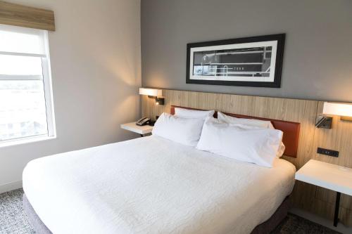 a hotel room with a white bed and a window at Hilton Garden Inn Savannah Historic District in Savannah