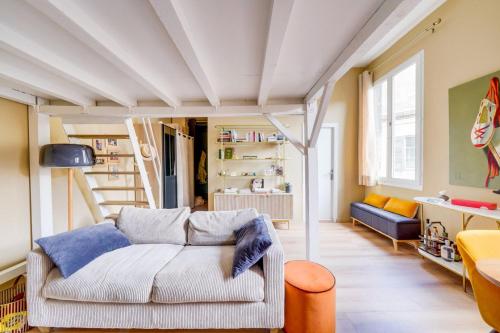 un salon avec un canapé et un escalier dans l'établissement Beautiful apartment Bordeaux Triangle d'Or, à Bordeaux