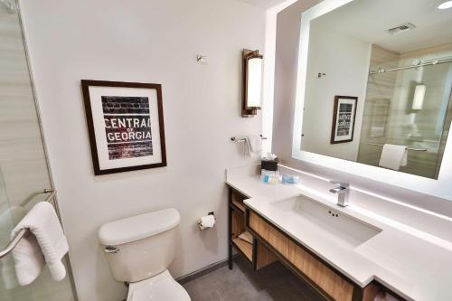 a bathroom with a sink and a toilet and a mirror at Hilton Garden Inn Savannah Historic District in Savannah