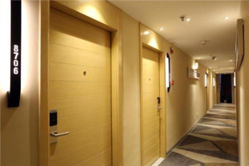 a hallway with wooden doors in a building at City Comfort Inn Changsha Hunan Mass Media College in Xingsha