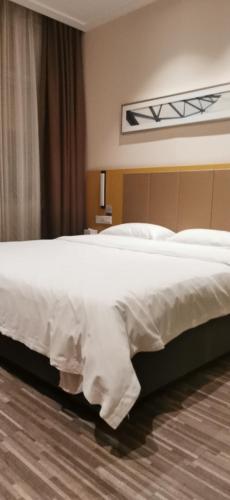 a bedroom with a large bed with white sheets at City Comfort Inn Changsha Hunan Mass Media College in Xingsha