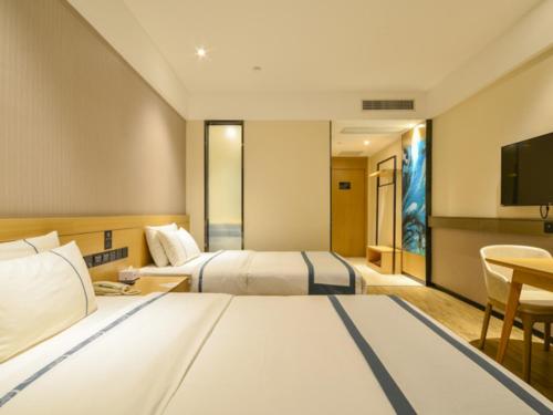 um quarto de hotel com duas camas e uma televisão em City Comfort Inn Suizhou Railway Station em Suizhou