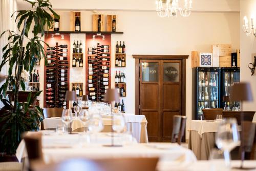 a restaurant with white tables and bottles of wine at Relais Villa Giuliana in Licata