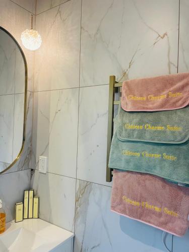 a bathroom with three towels on a towel rack at Delightful little house & Chateau Charme Suite in Auckland
