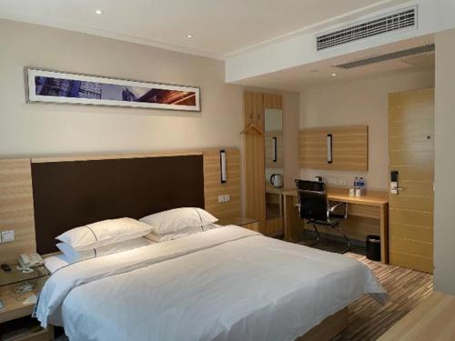 una camera con un grande letto bianco e una scrivania di City Comfort Inn Hefei Shuanggang Fuyang Road a Qilitangzhen