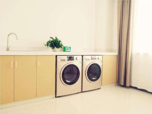 a kitchen with two washing machines and a sink at City Comfort Inn Luoyang Lijingmen Metro Station in Luoyang