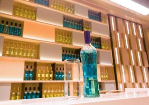 una botella y un vaso en un estante de una tienda en Echarm Hotel Huangshi Yingbin Avenue en Huangshi