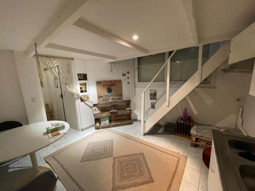 a living room with a staircase and a rug at Maisonnette en duplex 25 M2, Pantin porte de Paris in Pantin