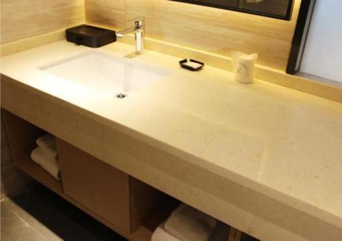 a sink in a bathroom with a mirror at City Comfort Inn Shiyan Beijing Road in Maojianqu