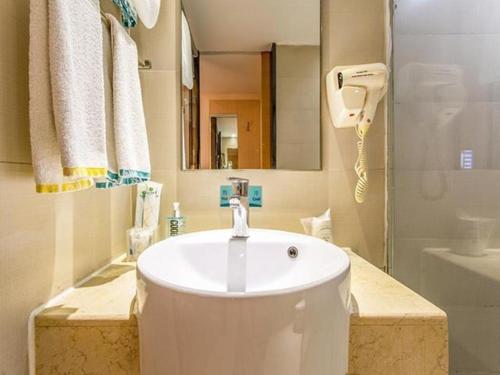 y baño con lavabo blanco y ducha. en City Comfort Inn Nanning Wuming en Wuming