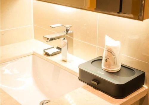 a bathroom with a sink and a soap dispenser at City Comfort Inn Ganzhou Economic Development Zone Wanda Plaza in Ganzhou
