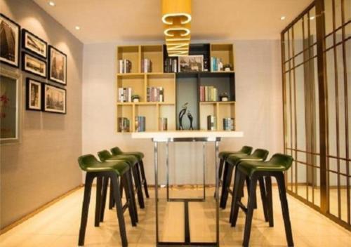 a bar with green stools in a room at City Comfort Inn Shangri-La Dukezong Ancient Town in Shangri-La