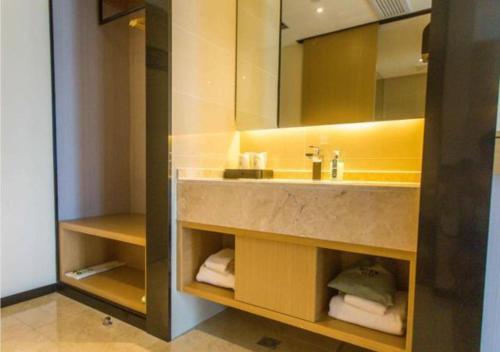 a bathroom with a sink and a mirror and towels at City Comfort Inn Xuancheng Wanda Qinglv Guoji in Xuanzhou