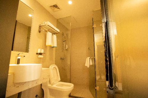 a bathroom with a toilet and a sink and a shower at City Comfort Inn Ganzhou Railway Station in Ganzhou