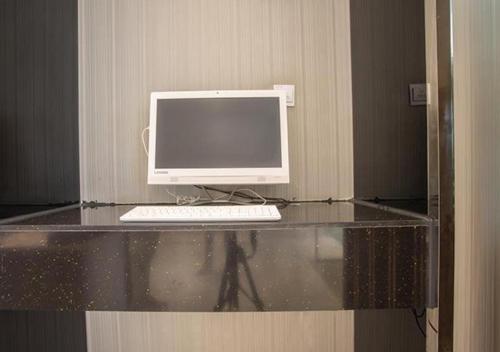 a desk with a computer on top of it at City Comfort Inn Nanning Chaoyang Square Theater Metro Station in Nanning