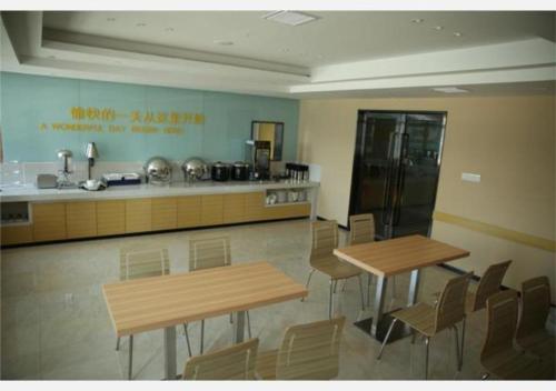 een kamer met 2 tafels en stoelen en een keuken bij City Comfort Inn Huangshi Yangxin Mingyuewan Park in Yangxin
