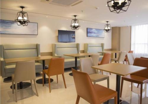 南寧市にあるCity Comfort Inn Nanning Xiangsi Lake Gaoxin Avenueのダイニングルーム(テーブル、椅子、照明付)