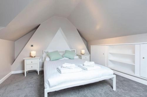een slaapkamer met een wit bed en 2 nachtkastjes bij Central - Family House in Harrogate