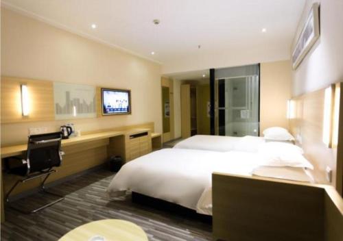 a hotel room with a bed and a desk and a television at City Comfort Inn Foshan Longjiang Exhibition Center in Shunde