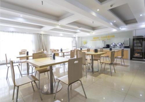 a restaurant with tables and chairs in a room at City Comfort Inn Foshan Longjiang Exhibition Center in Shunde