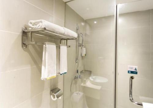 a bathroom with a shower and a toilet and a sink at City Comfort Inn Foshan Longjiang Exhibition Center in Shunde