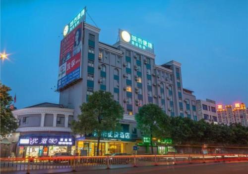 ein großes Gebäude mit einer Uhr darüber in der Unterkunft City Comfort Inn Wuzhou Teng County Bus Station in Tengcheng