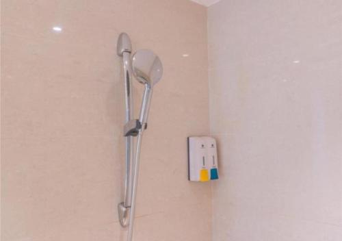 a shower in a bathroom with a phone on the wall at City Comfort Inn Wuzhou Teng County Bus Station in Tengcheng