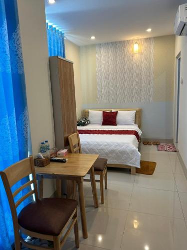 a bedroom with a bed and a table and a table and chairs at Nhà nghỉ Kim Cương in Rạch Giá