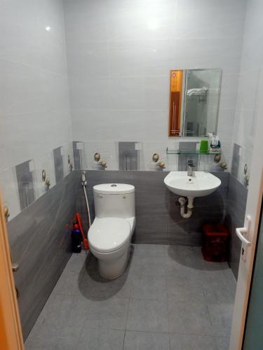 a bathroom with a toilet and a sink at Nhà nghỉ Kim Cương in Rạch Giá