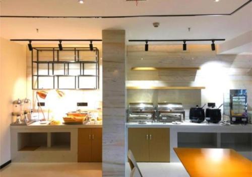 eine große Küche mit einer Theke und einer Arbeitsplatte in der Unterkunft City Comfort Inn Ezhou Hengda in Ezhou