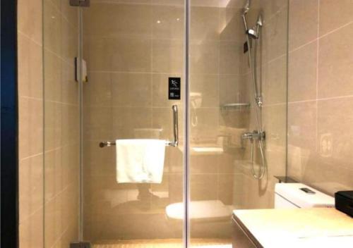 W łazience znajduje się przeszklony prysznic i toaleta. w obiekcie City Comfort Inn Ezhou Hengda w mieście Ezhou