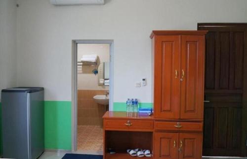 uma casa de banho com um armário de madeira e um lavatório em Hotel Meigah em Tanjung Pandan