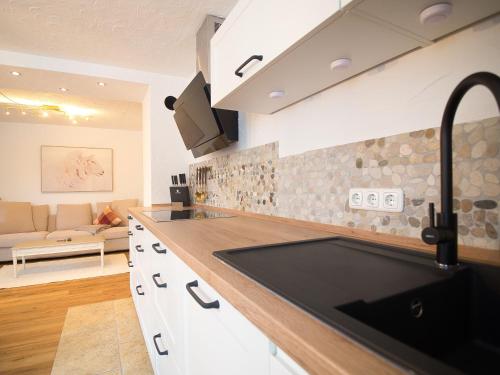 eine Küche mit einem Waschbecken und ein Wohnzimmer in der Unterkunft Ferienhäuschen Storchennest in Schönau am Königssee