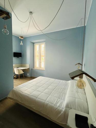 a bedroom with a large bed and a desk at La Maison in Grottammare