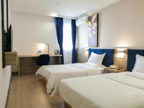 a hotel room with two beds and a television at 7 Days Premium Xianning Wenquan Shopping Center in Guanbuqiao
