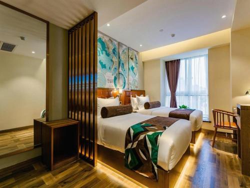 XianyangにあるJames Joyce Coffetel· Xianyang Renmin Road Central Square Storeのベッド2台と窓が備わるホテルルームです。